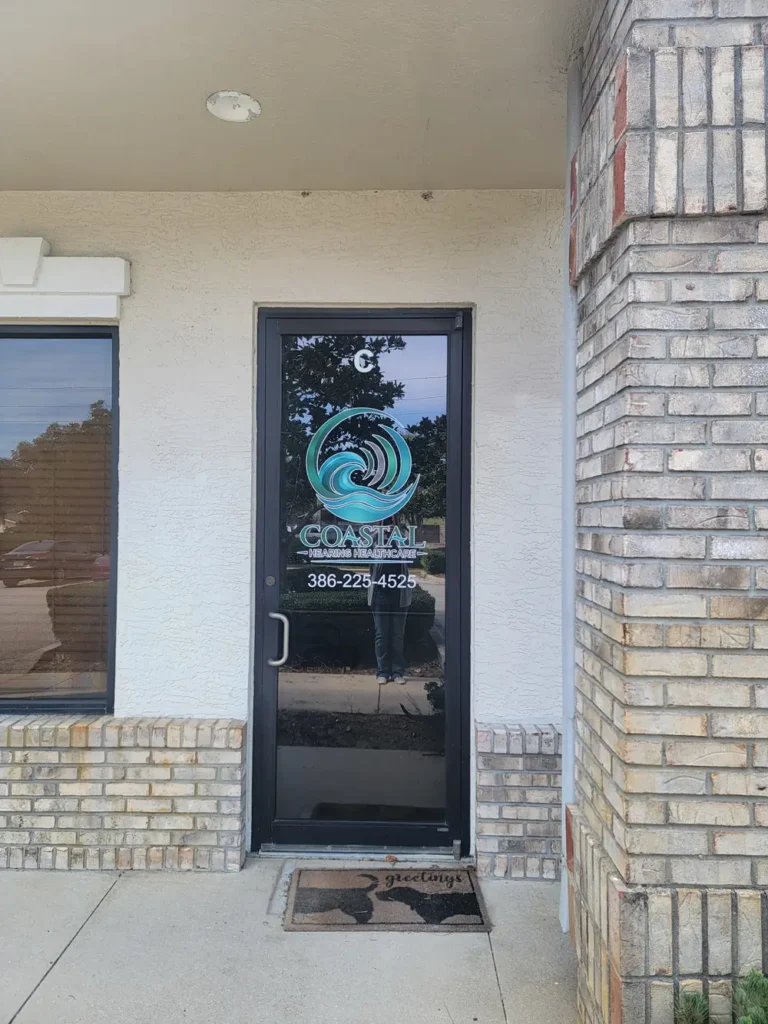 The Suite C entrance, with the Coastal Hearing Healthcare logo and phone number on the glass door.